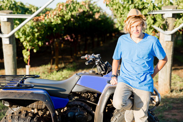 Boy standing next to truck in vineyard