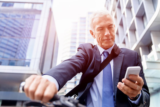 Successful businessman riding bicycle