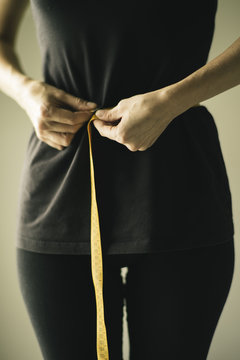 Mid-adult woman measuring waist