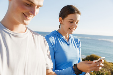 Young couple with smartphones outdoors