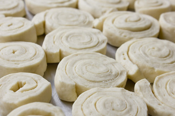 Spiral cinnamon buns from yeast dough on a baking sheet. Homemade baking.