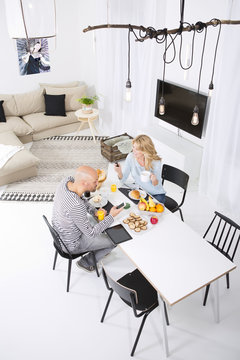 Couple at breakfast table using smart phones