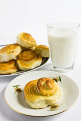 Breakfast with cinnamon buns and glass of milk on a white background. Homemade baking.