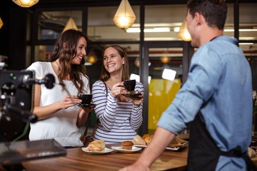 Smiling friends having coffee