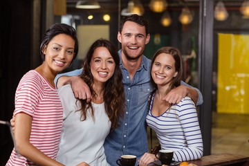 Smiling friends having coffee