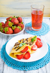 Pancakes with sliced strawberries and chocolate