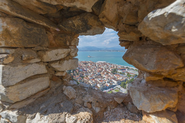 Looking at the old city of Nafplio, Greece through a stone windo