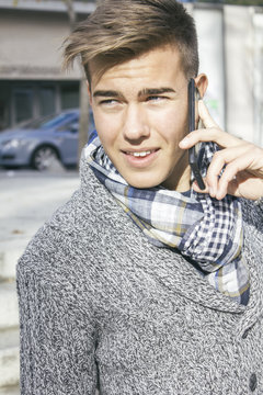 Portrait of teenage boy telephoning with smartphone