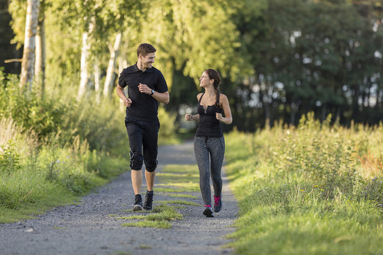 Man and woman jogging on rural path
