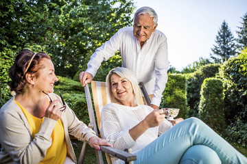 Elderly friends relaxing in garden