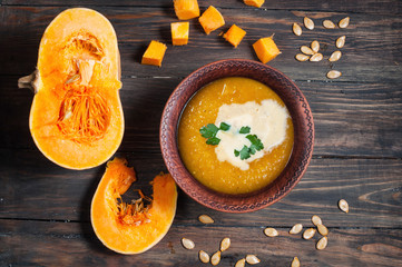 Pumpkin thick soup in rustic style on a wooden background