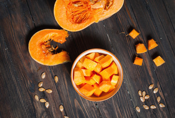 Ripe pumpkin cut slices on a wooden background. 