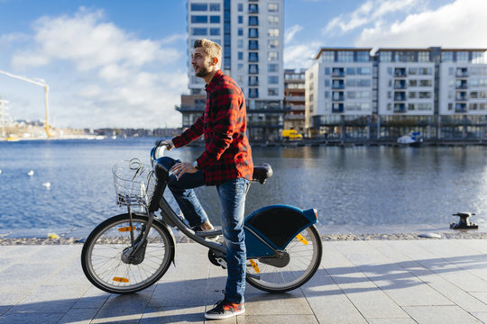 Ireland, Dublin, young man at city dock with city bike