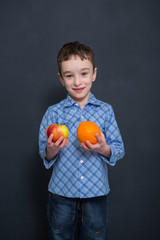 break for fruits, boy holding apple and orange
