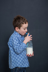 Cheerful smiling boy drinking milk
