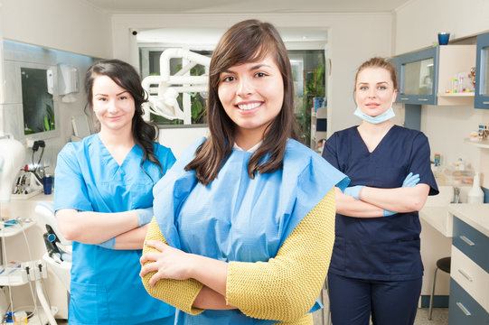 Portrait of beautiful woman patient with dental team in backgrou