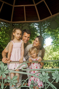 Family with two girls standing in gazebo at park