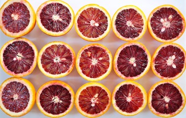 Ruby red blood oranges cut in half on a white platter