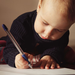 Little beautiful girl writing in her book