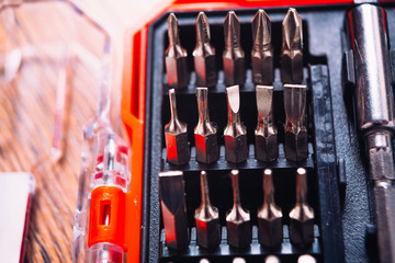 set of nozzles for screwdriver in red box on wooden background