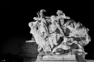 Image of a statue of Victor Emmanuel II bridge with winged victories travertine. Rome at night .
