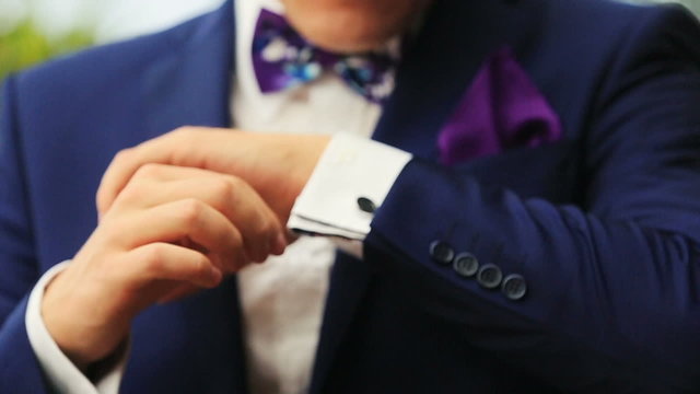 Stylish groom in blue luxury suit wearing cufflinks close up