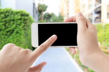 Female hand touching smartphone in garden