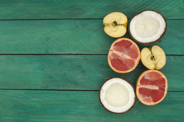 sliced fruit - grapefruit, coconut, apple, on a wooden background. 
