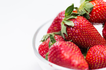 close up of ripe red strawberries over white