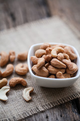 Salted cashew nuts in bowl on sackcloth