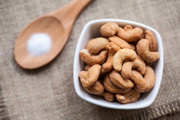 Salted cashew nuts in bowl on sackcloth