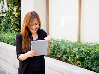 Excited woman using digital tablet