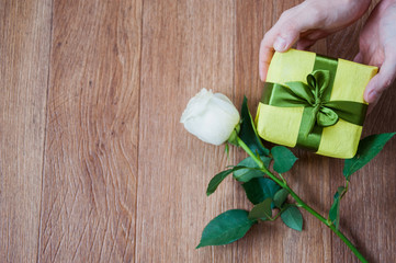 gift in their hands and a rose
