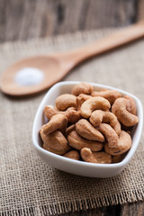 Salted cashew nuts in bowl on sackcloth