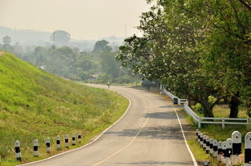 Fototapeta na wymiar Beautiful road in the middle of beautiful tree and hill at Chon Buri Province in Thailand