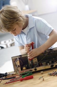 Little boy disassembling an old radio