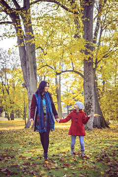Mother and daughter walking in autumnal park
