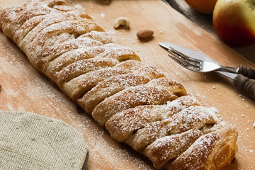 Uncooked homemade rustic apple pie preparation greased with egg yolk on white kitchen background