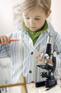 Portrait of little boy with test tubes and microscope
