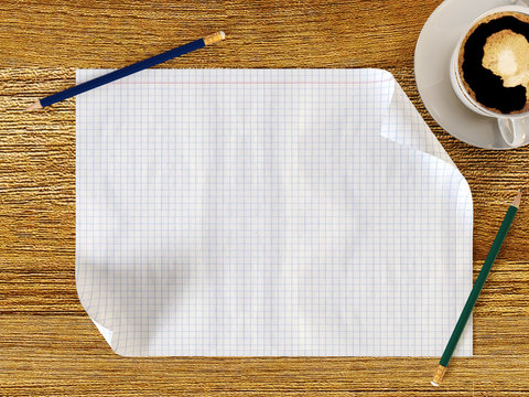 Blank paper on wood table with pencils and coffee cup