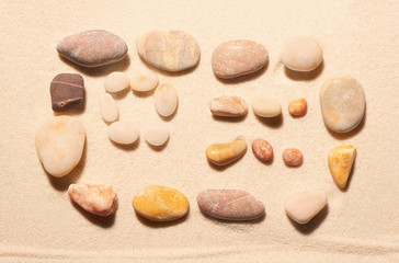 Fototapeta na wymiar Airplane ticket from sea stones on sand. Summer beach background