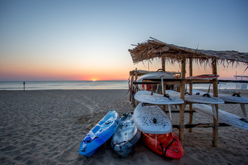 Equipment einer Surfschule am Strand im Sonnenaufgang