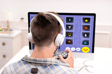 Fototapeta na wymiar Young man playing computer games at home