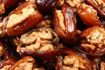 Walnut and date fruit on wooden table, close-up