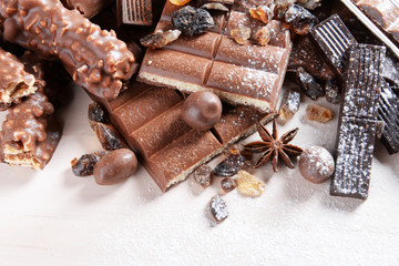 Chocolate sweets with powder on wooden background