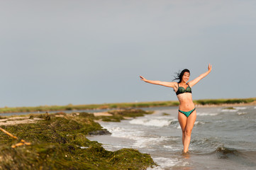 Beautiful girl sunbathing and swimming in the sea