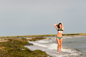 Fototapeta na wymiar Beautiful girl sunbathing and swimming in the sea