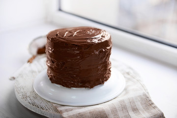 Chocolate cake on a plate on unfocused background