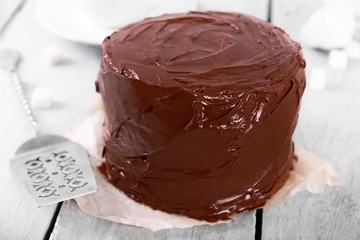 Chocolate cake with blade on a wooden table background