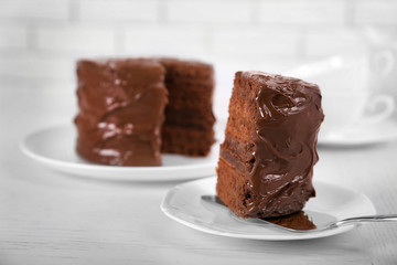 Chocolate cake on plates with a cut piece on unfocused background